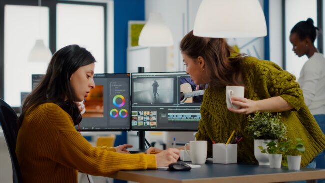Colleagues discussing about video project adjusting film footage